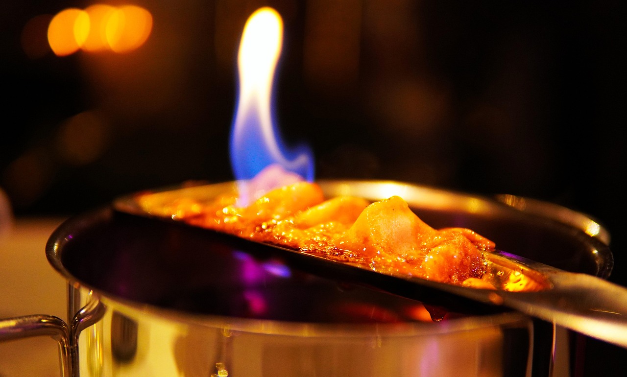 Caramello riscaldato che si scioglie in una pentola, creando una consistenza liscia e lucente.