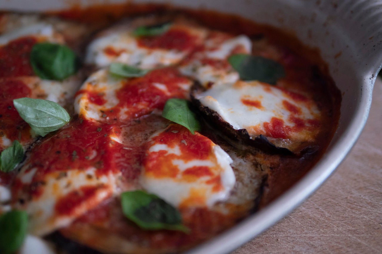 Melanzane alla parmigiana appena sfornate, ricoperte di mozzarella e basilico fresco.