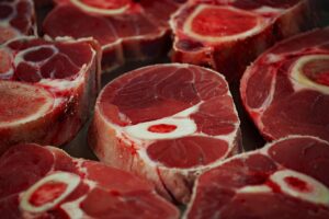 Carne appena estratta dal frigo, evidenziando l'errore di cucinarla a temperatura troppo bassa.