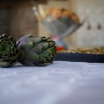 Carciofi ripieni in un piatto, pronti per essere serviti, con ingredienti freschi e colorati.