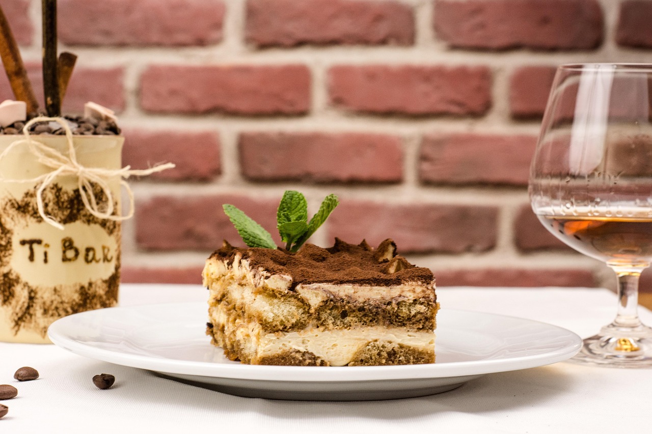 Tiramisù senza uova in una ciotola, decorato con cacao e savoiardi, ricetta leggera e golosa.