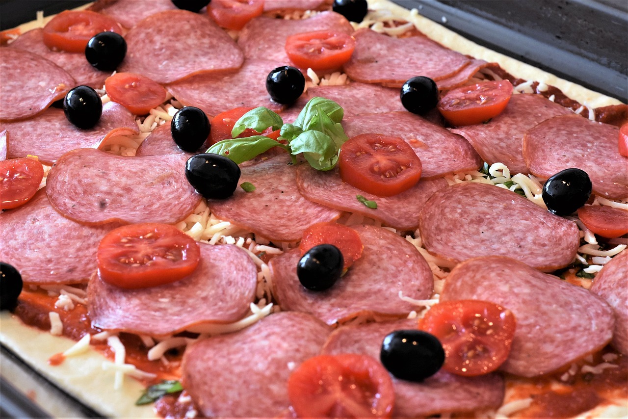 Pizza cruda con ingredienti freschi, evidenziando la cottura non ottimale.