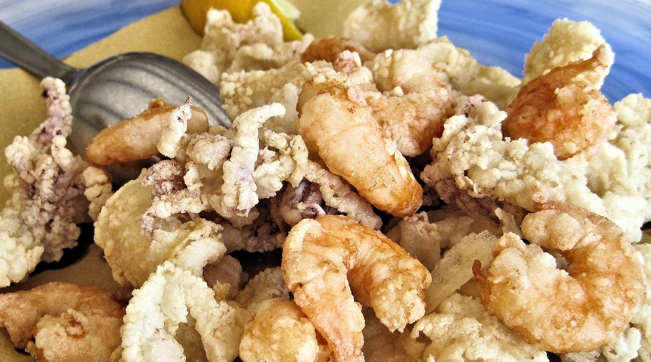 Calamari fritti con pastella croccante a base di birra, serviti su un piatto bianco.