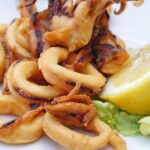Preparazione della pastella per calamari fritti in una ciotola con ingredienti freschi.