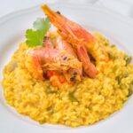 Risotto ai frutti di mare con gamberi e cozze, impiattato elegantemente.
